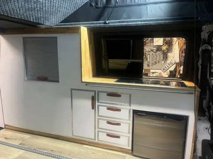 Zabudowa kuchenna z lodówką, szufladami i schowkiem pod oknem