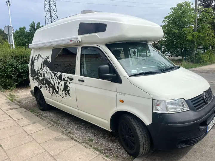 Biały VW T5 z wysokim dachem i grafiką górską na boku